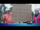 Couple hands out cash on street corner